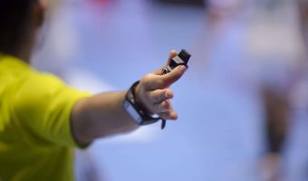 Shallow depth of field with handball referee hand holding a whis